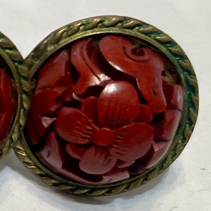 Red carved floral button with brass frame