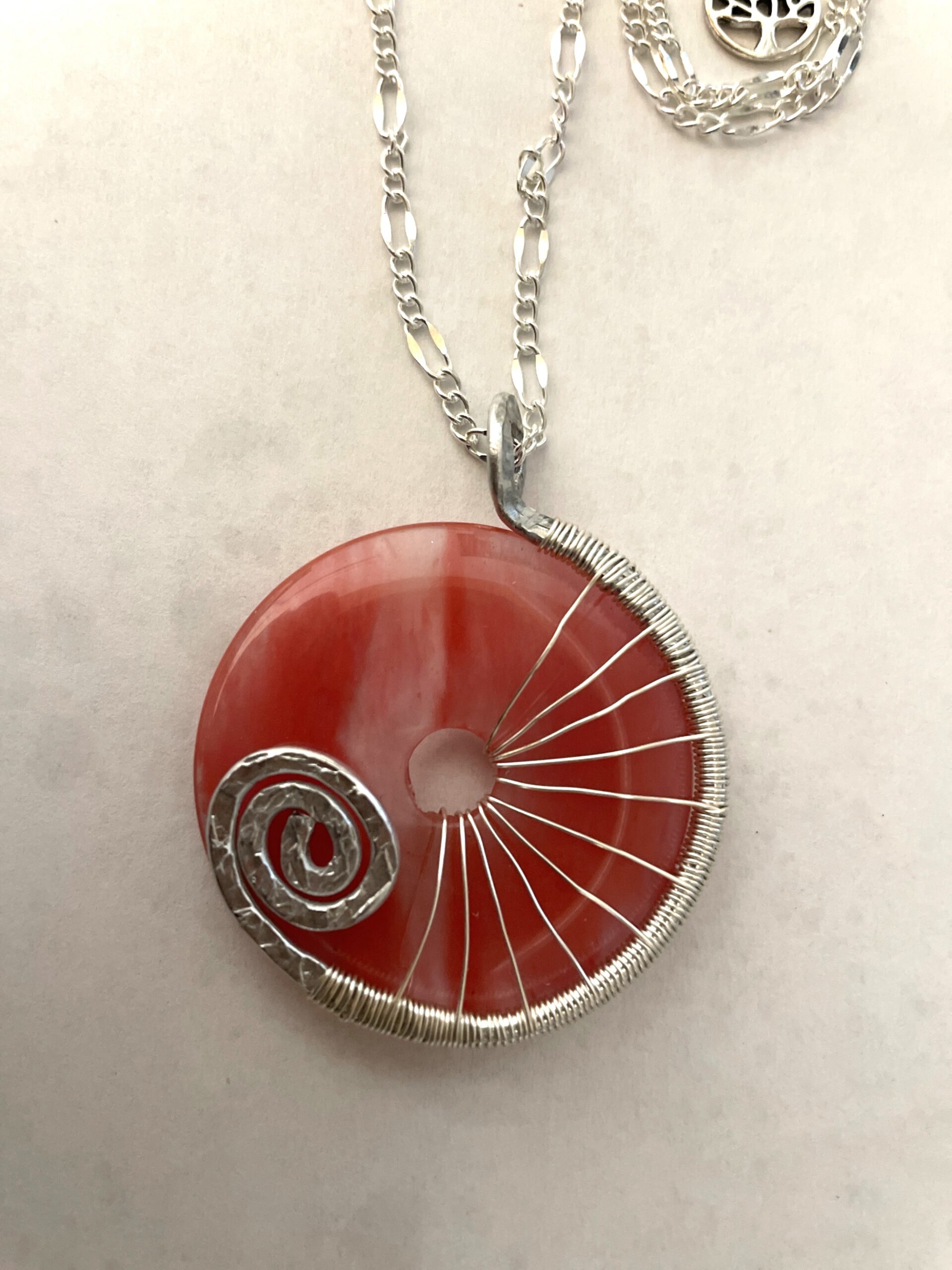 Elegant red donut pendant with wire design