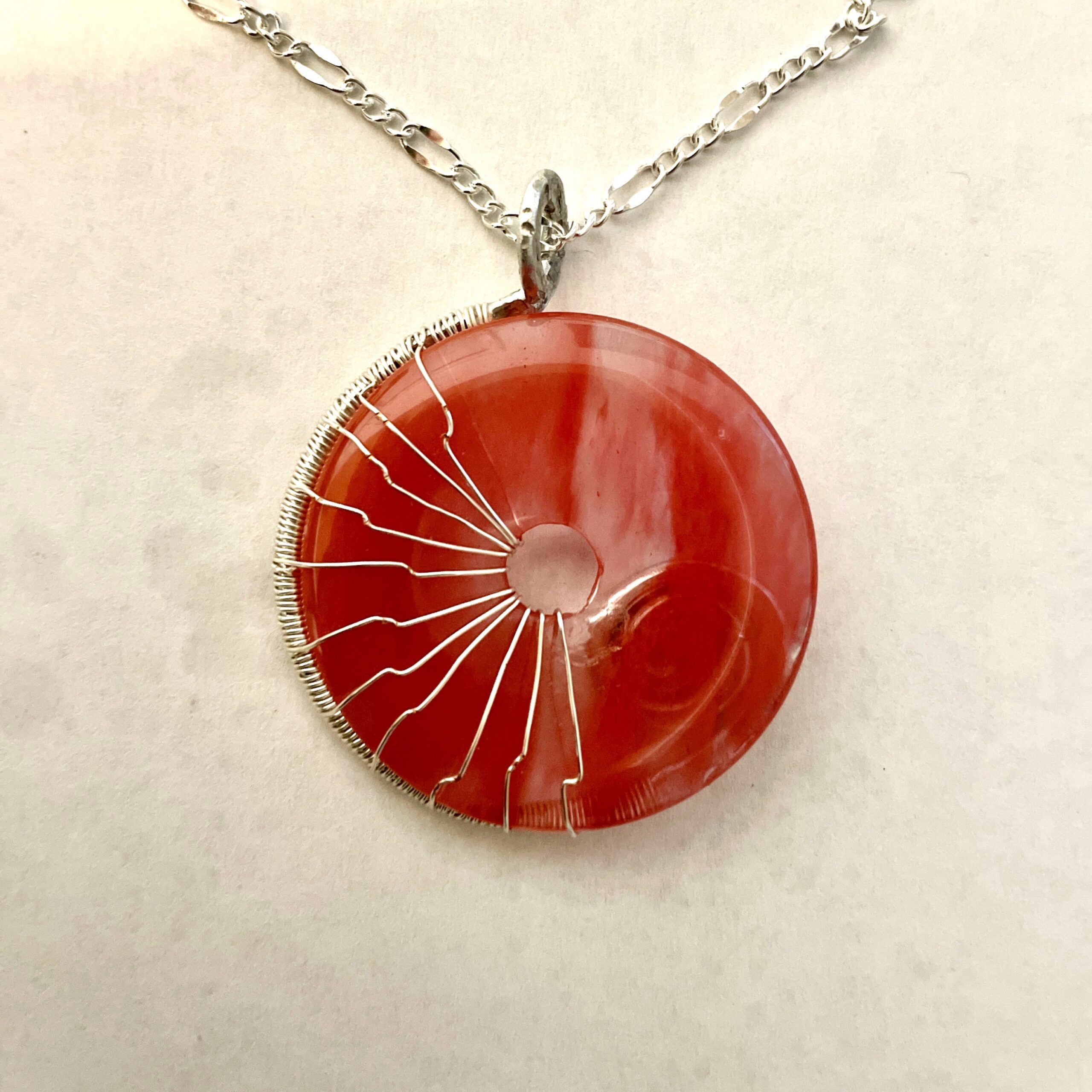 Wire-wrapped red agate donut pendant
