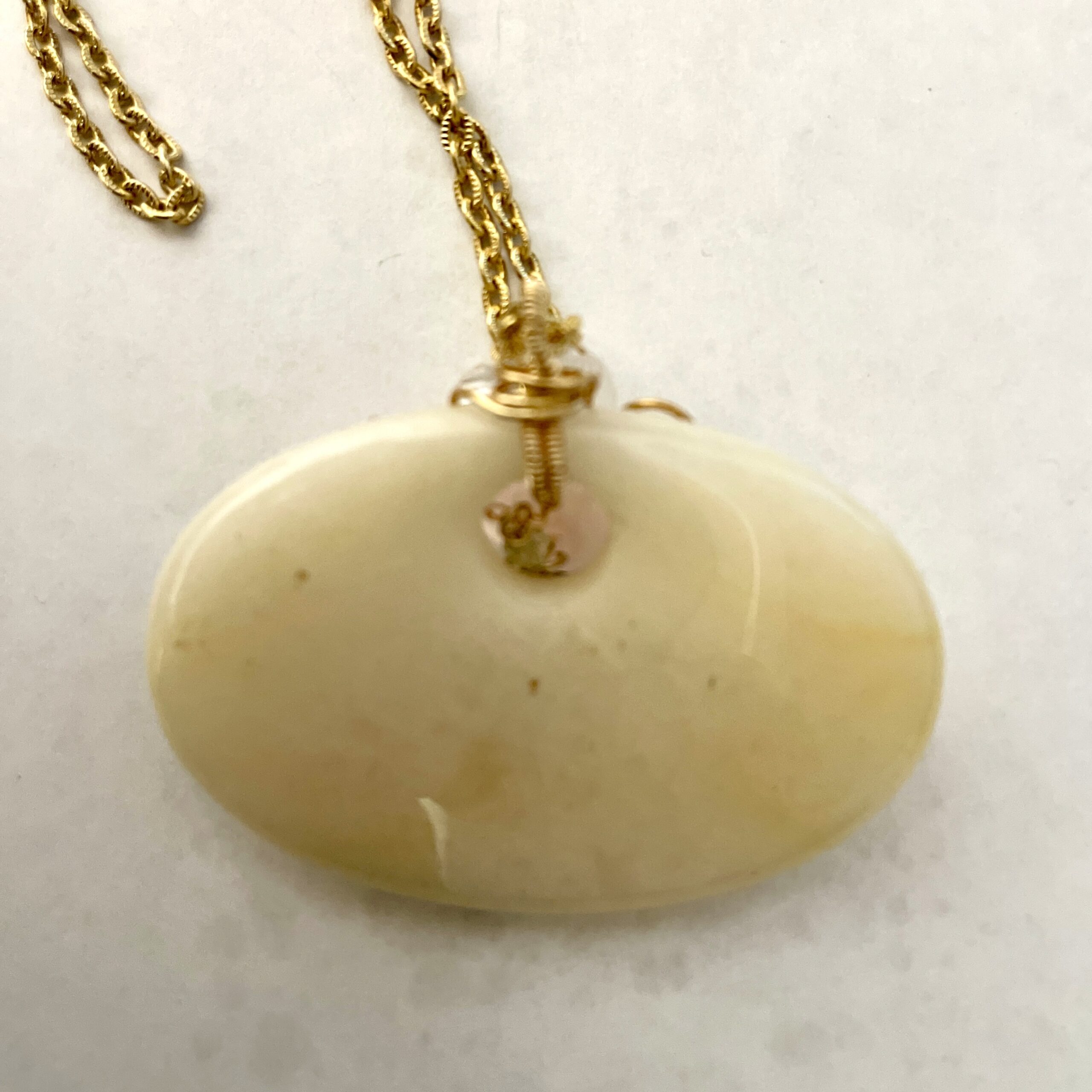 Oval cream stone pendant on gold chain