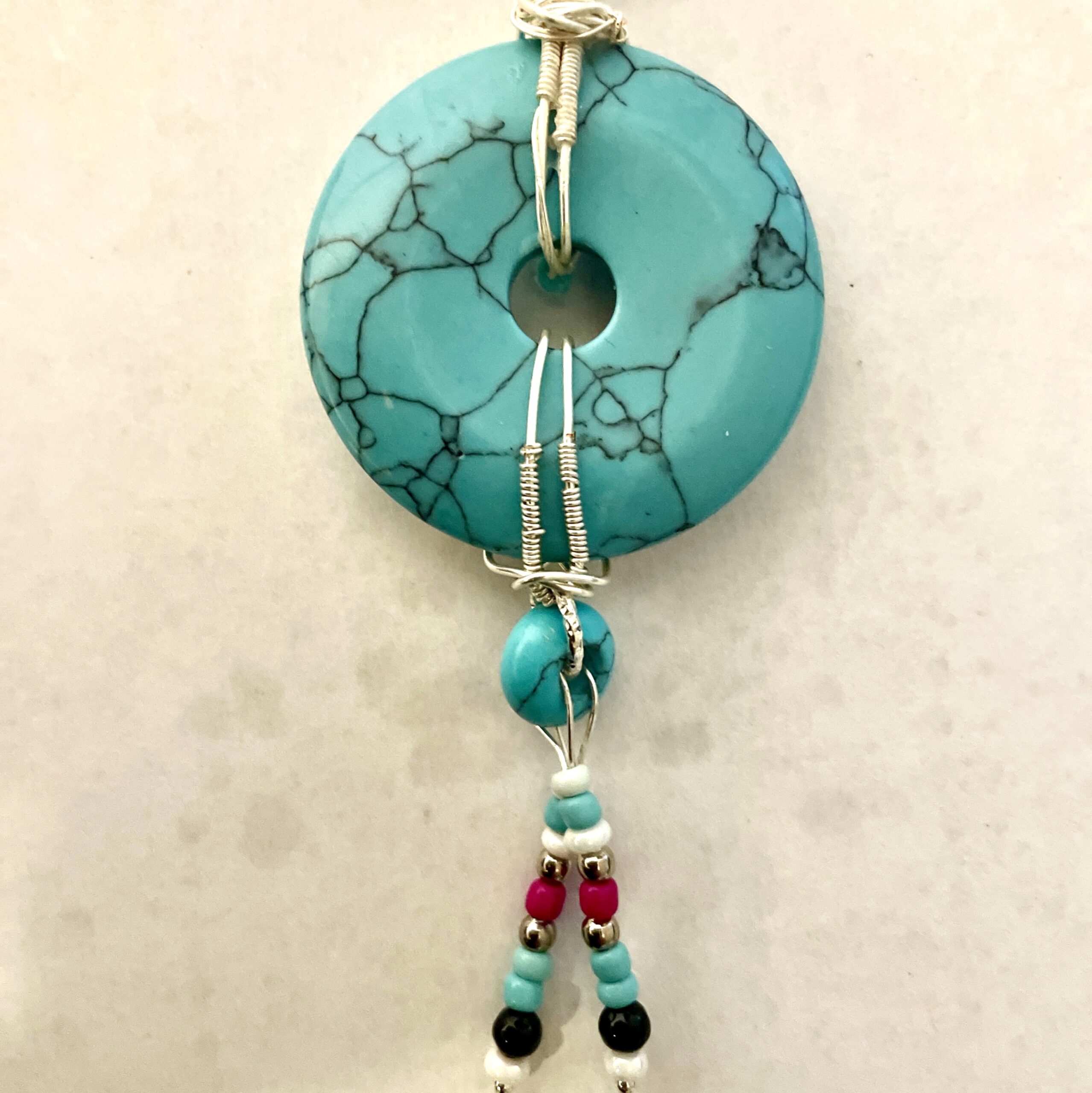 Wire-wrapped turquoise donut pendant with beads