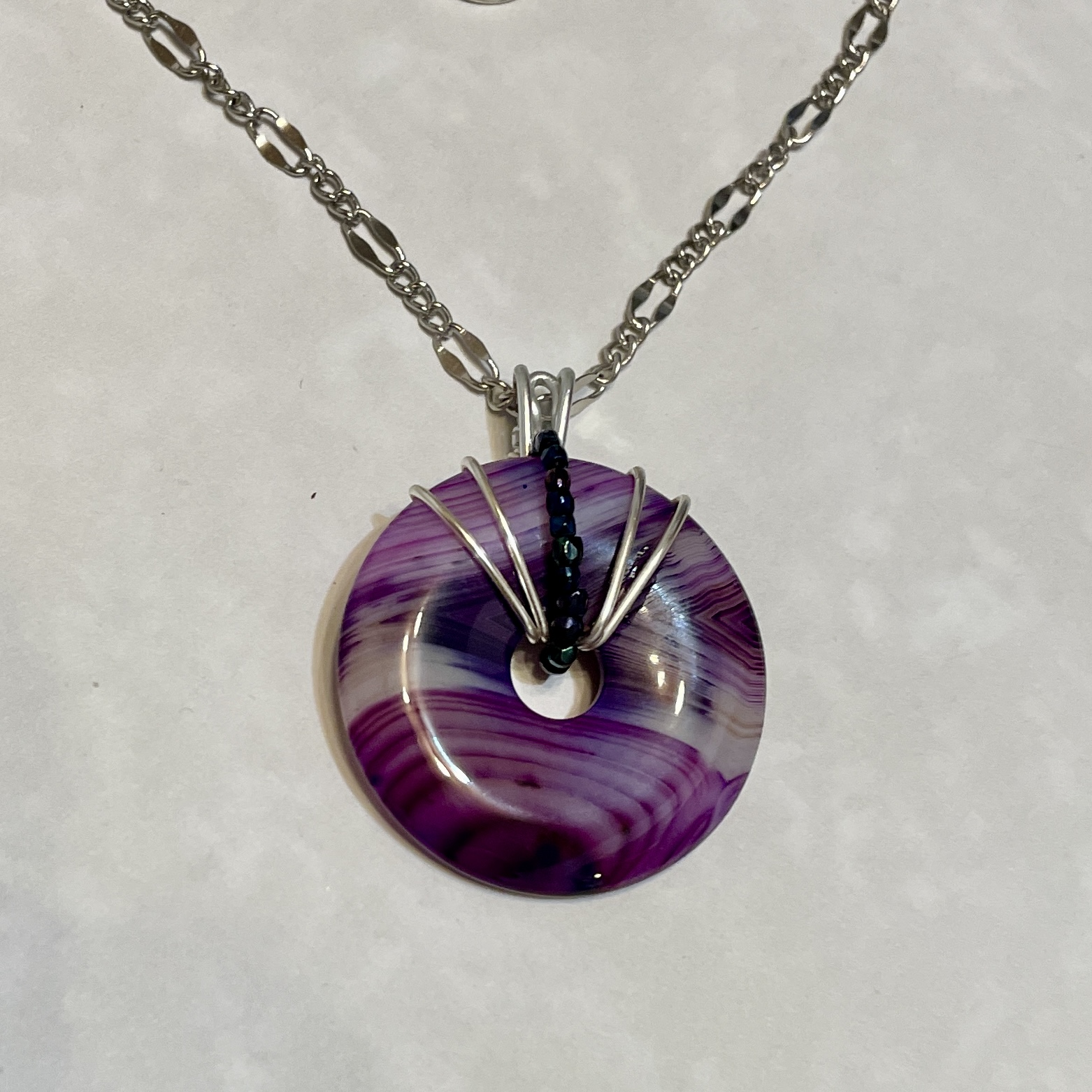 Purple swirl glass donut pendant on chain