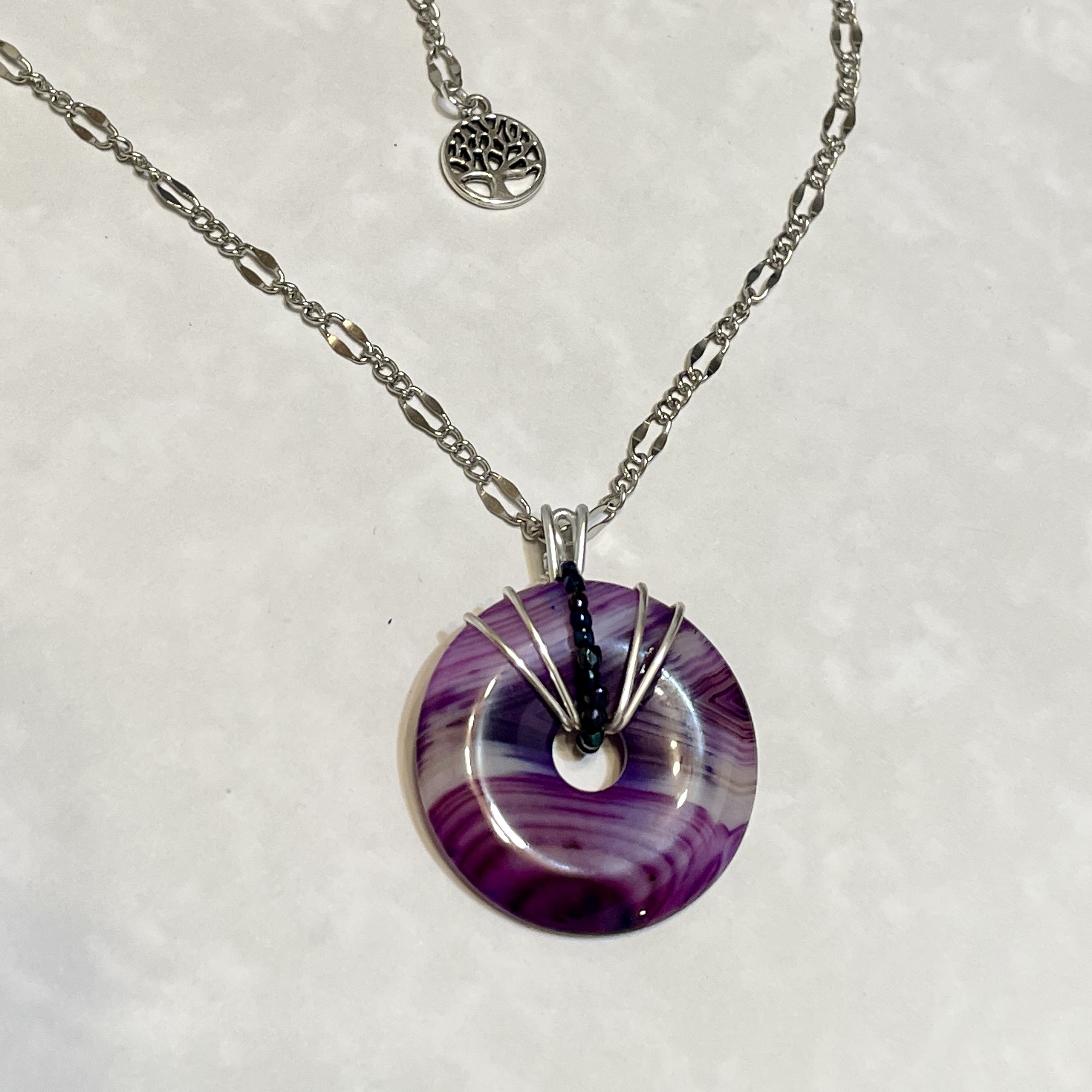 Purple swirl donut pendant on silver chain