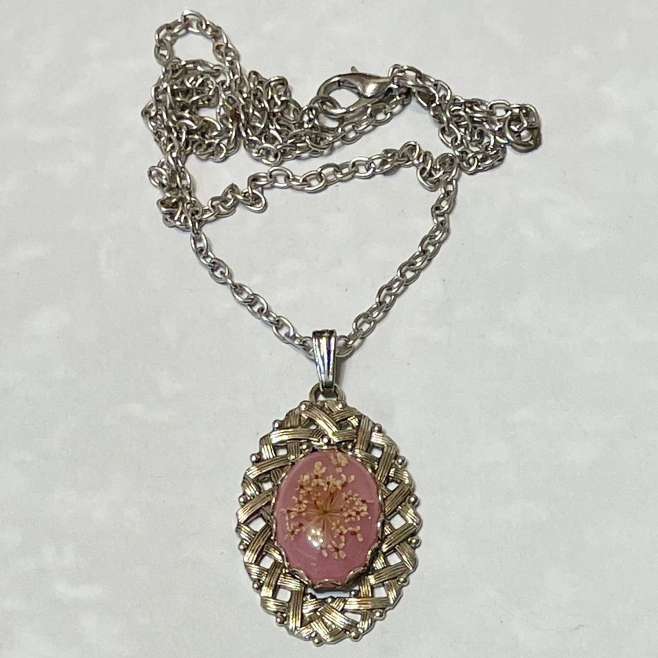 Oval pink floral pendant on silver chain