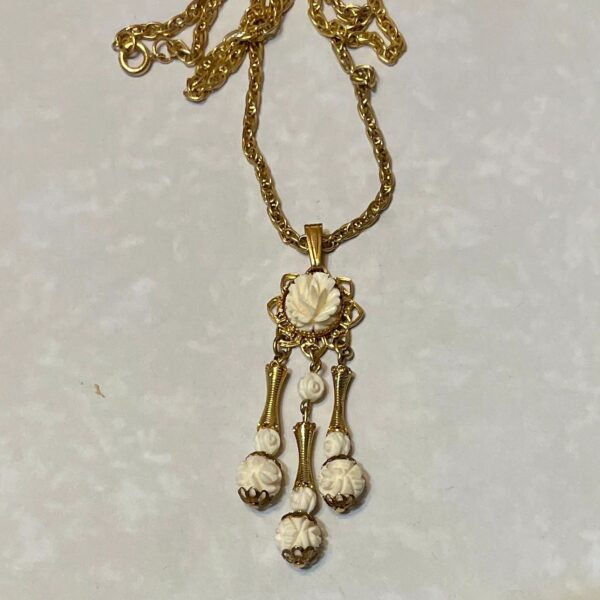 Gold chain with carved white floral pendant
