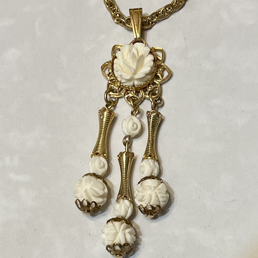 Gold pendant with carved white floral drops