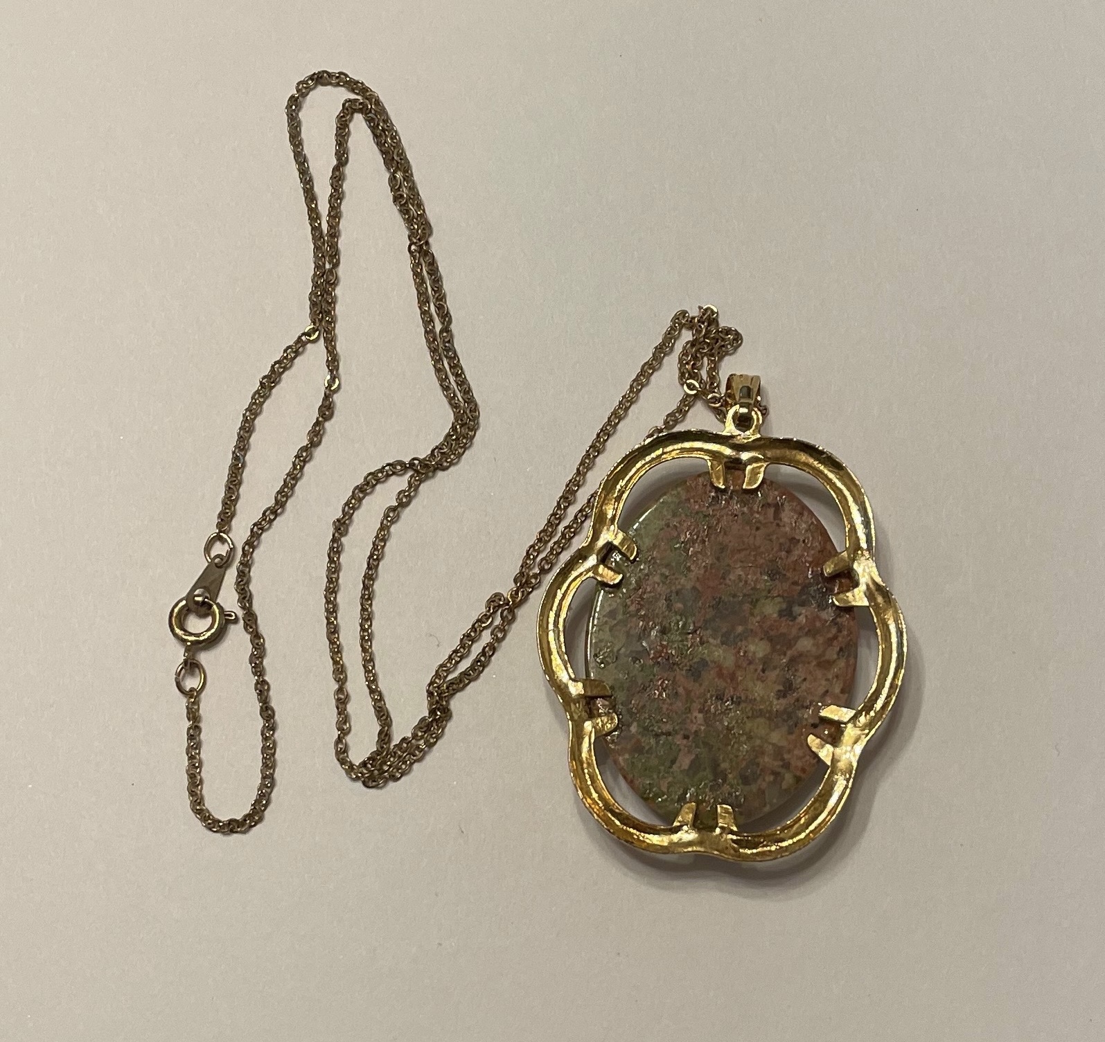 Gold pendant necklace with mottled oval stone