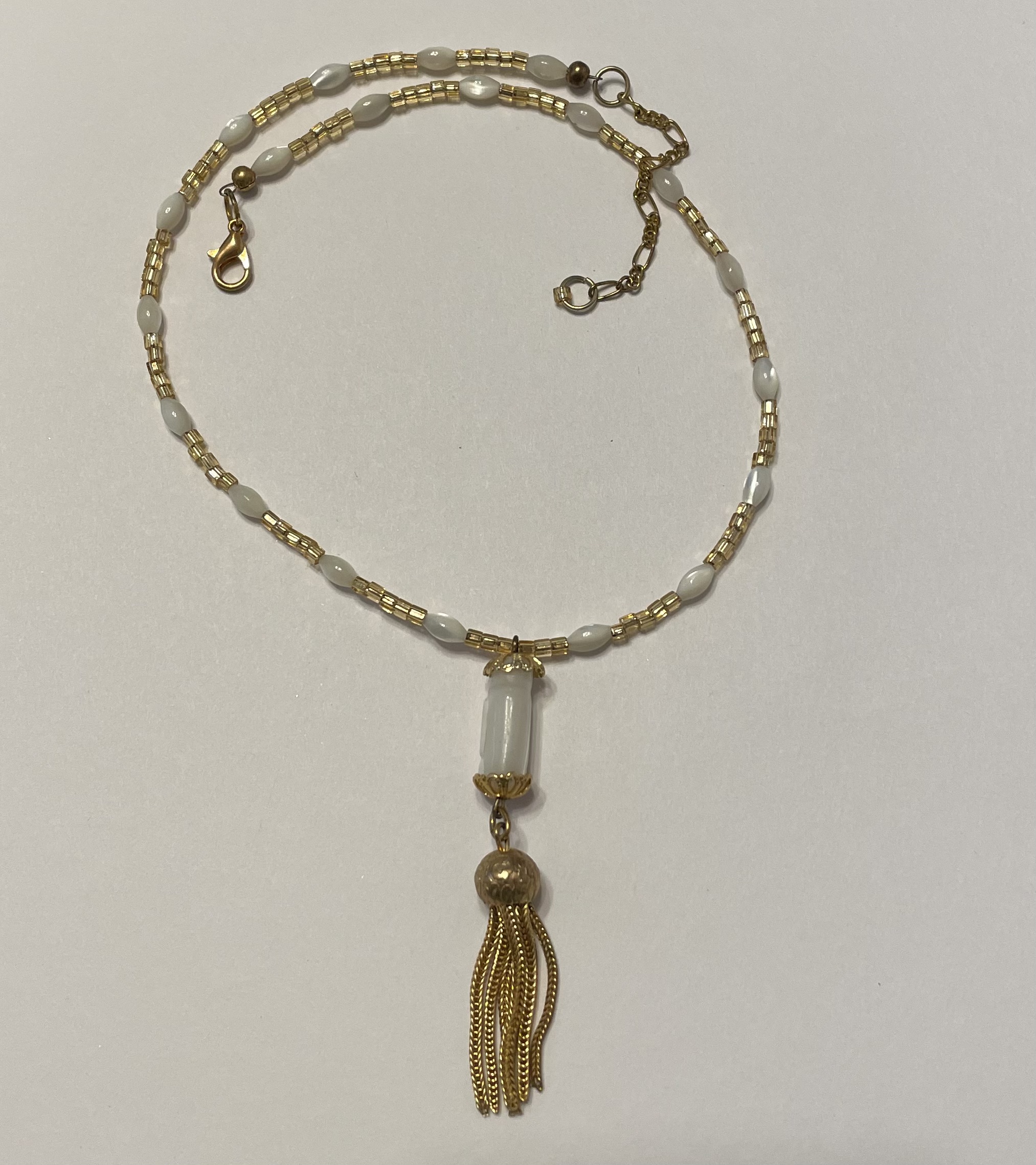 Gold and white beaded necklace with tassel