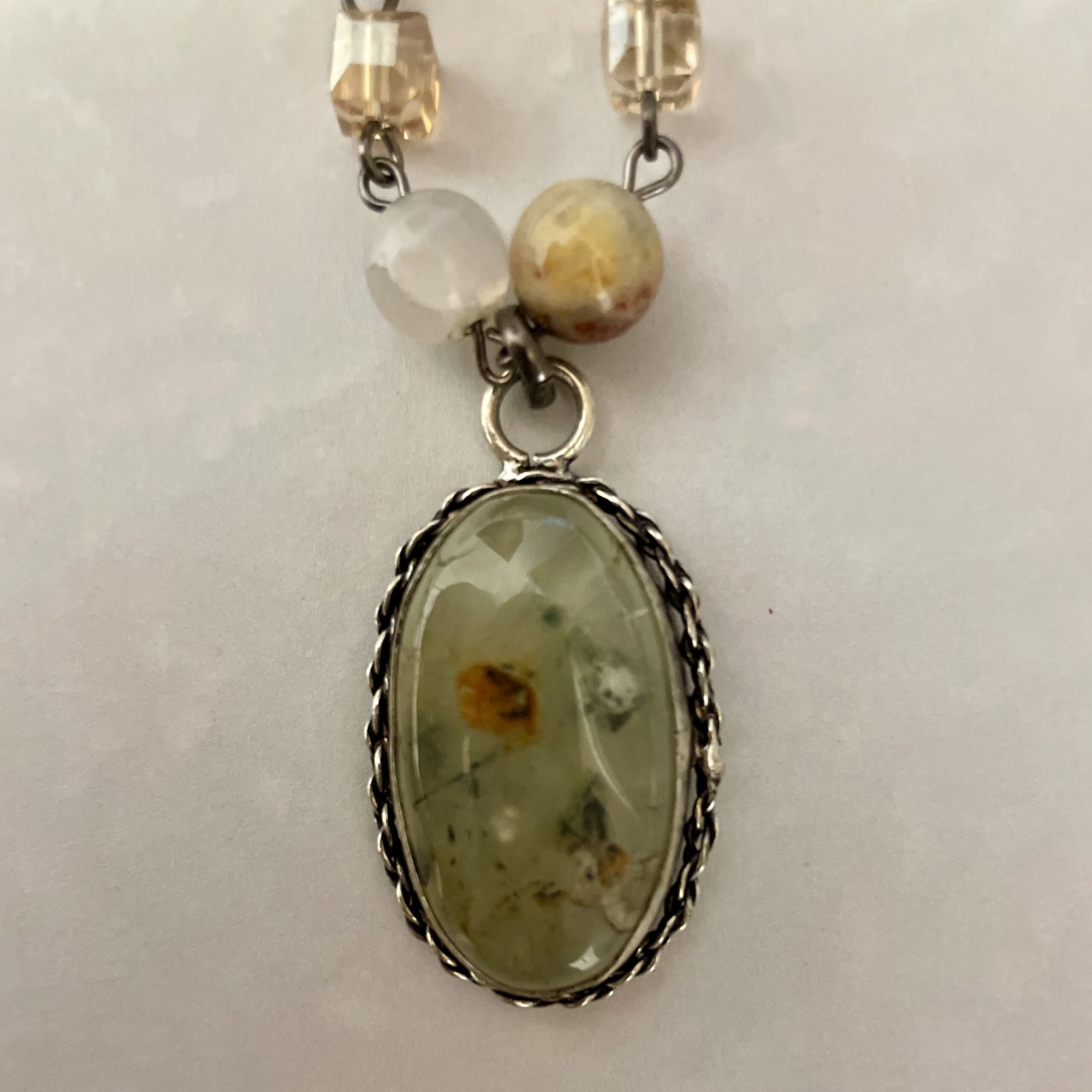 Oval green gemstone pendant with beaded chain