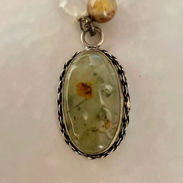 Oval greenish gemstone pendant with silver bezel