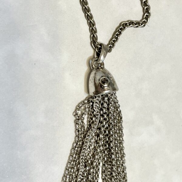 Silver chain tassel necklace on white background