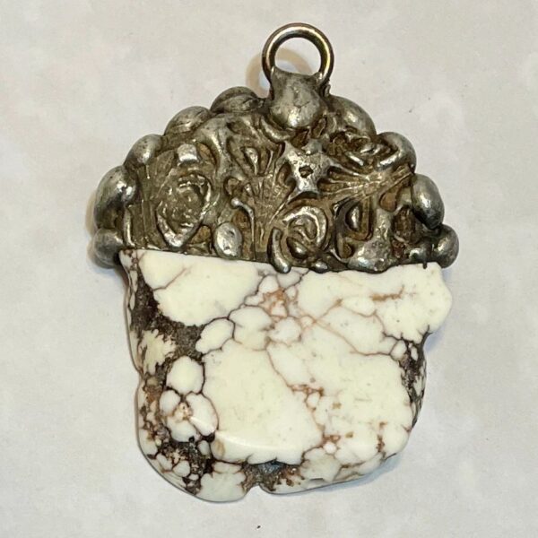 White veined stone pendant with ornate silver cap
