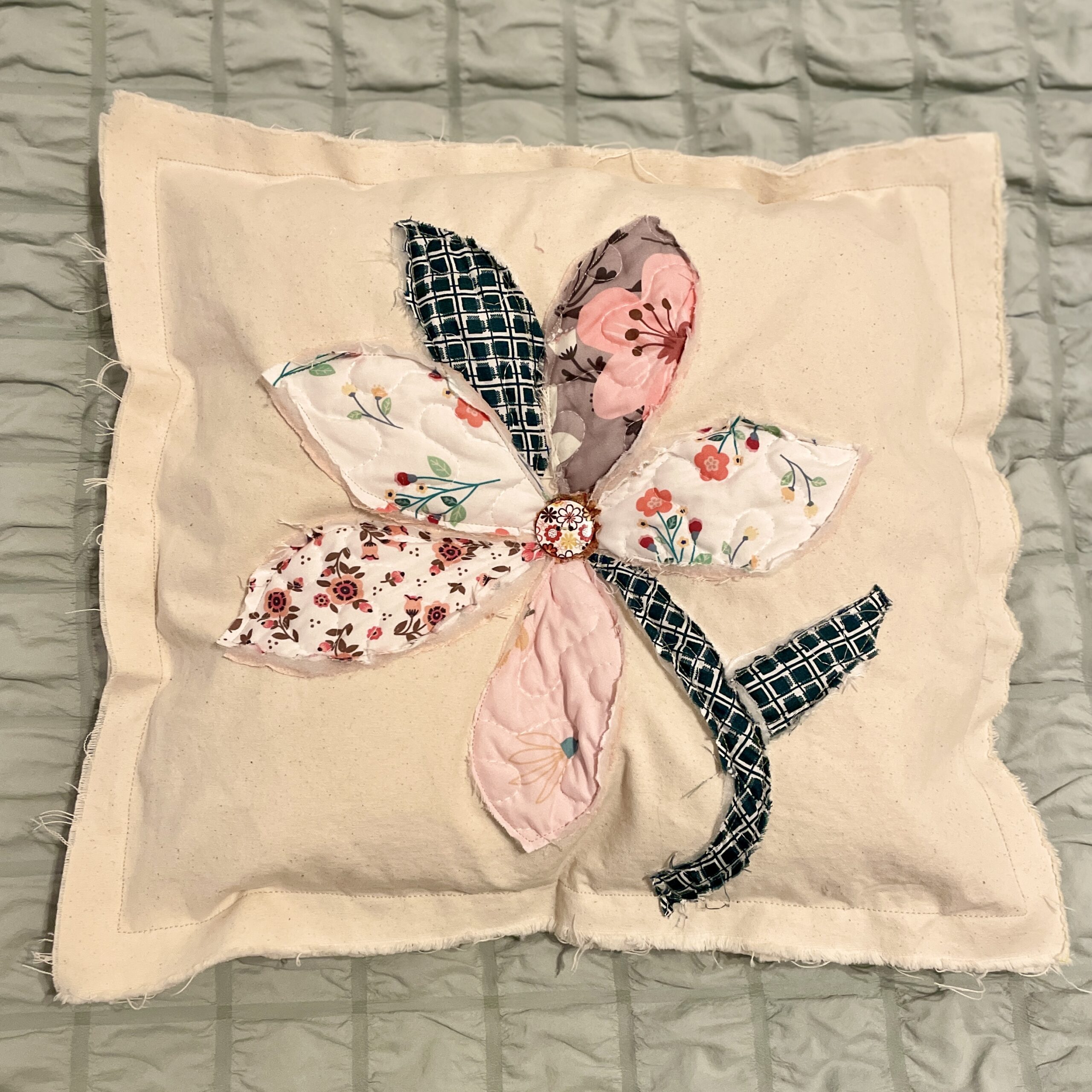 Fabric flower applique on cream pillow cover