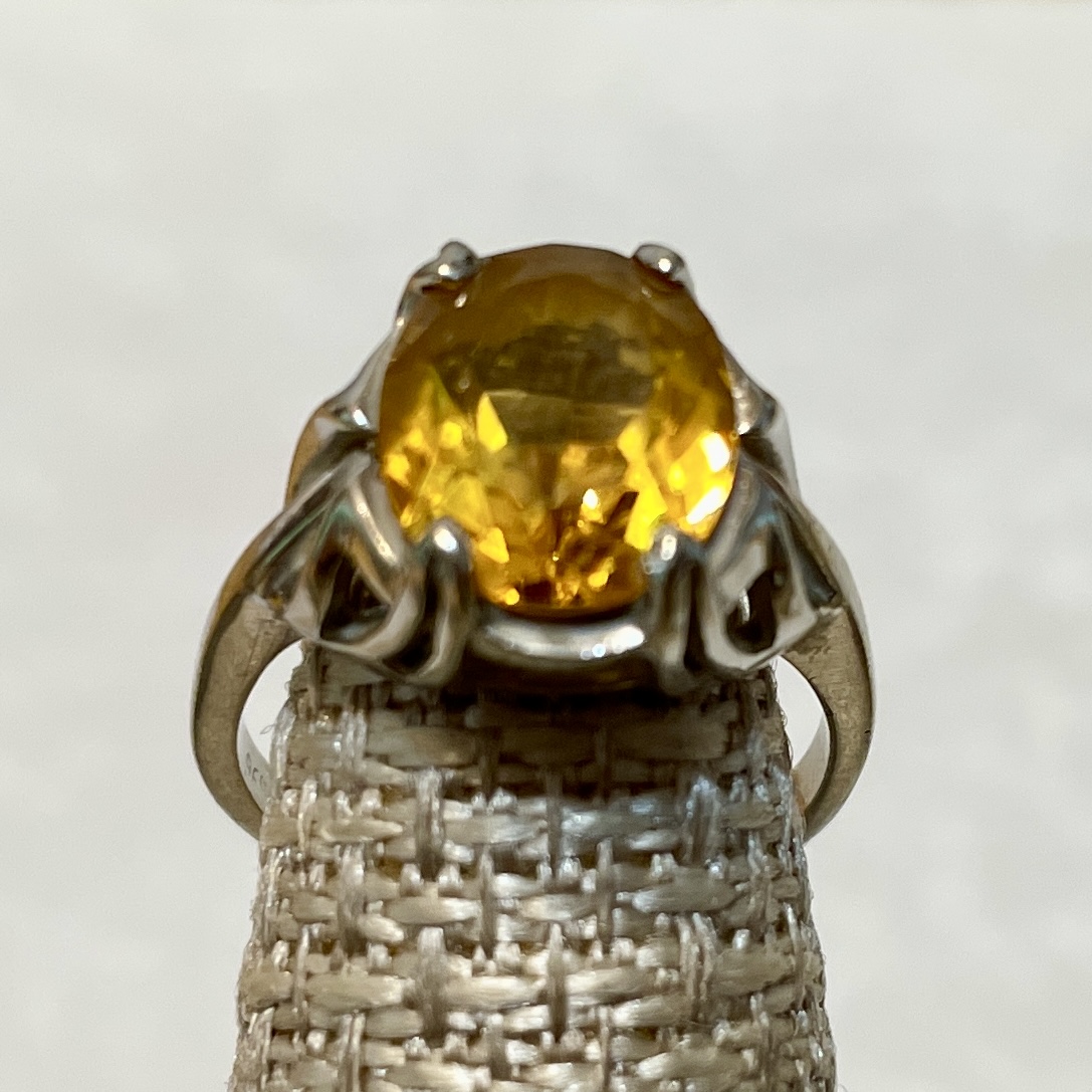 Elegant silver ring featuring a large yellow gem.