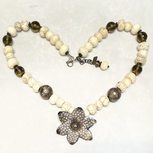 Beaded necklace with metal flower pendant