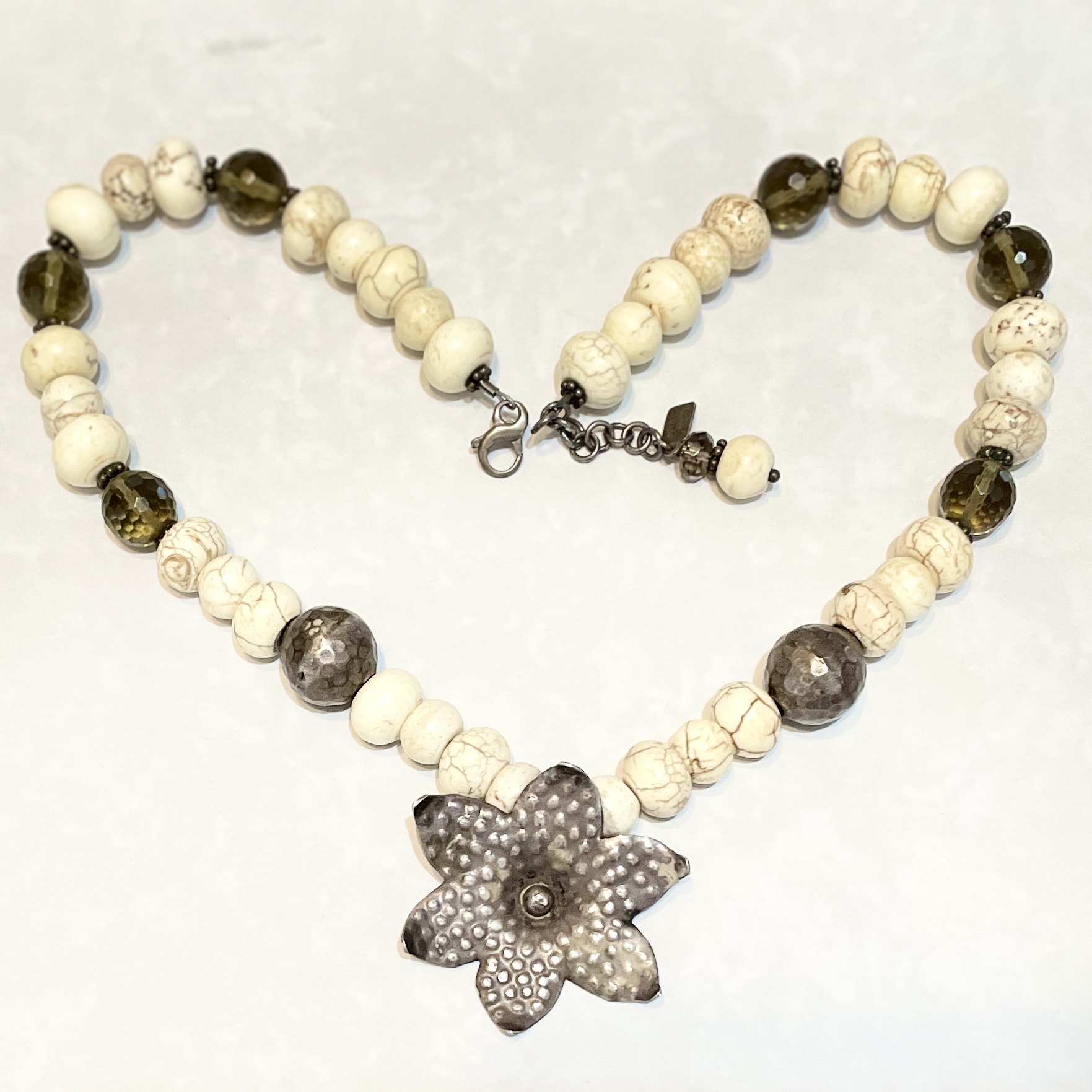 Beaded necklace with metal flower pendant