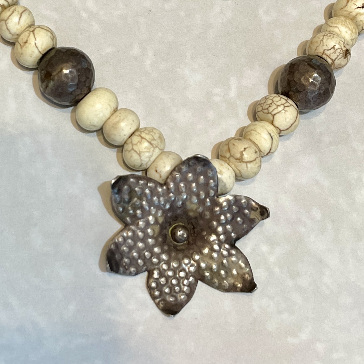Necklace with floral metal pendant