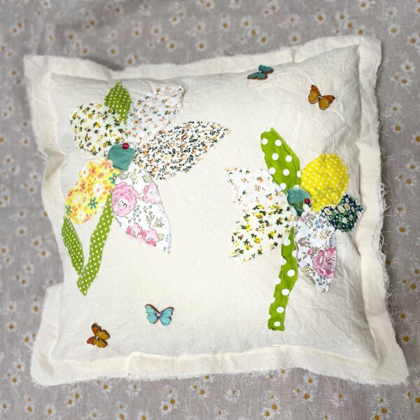 White pillow with floral fabric applique and butterflies