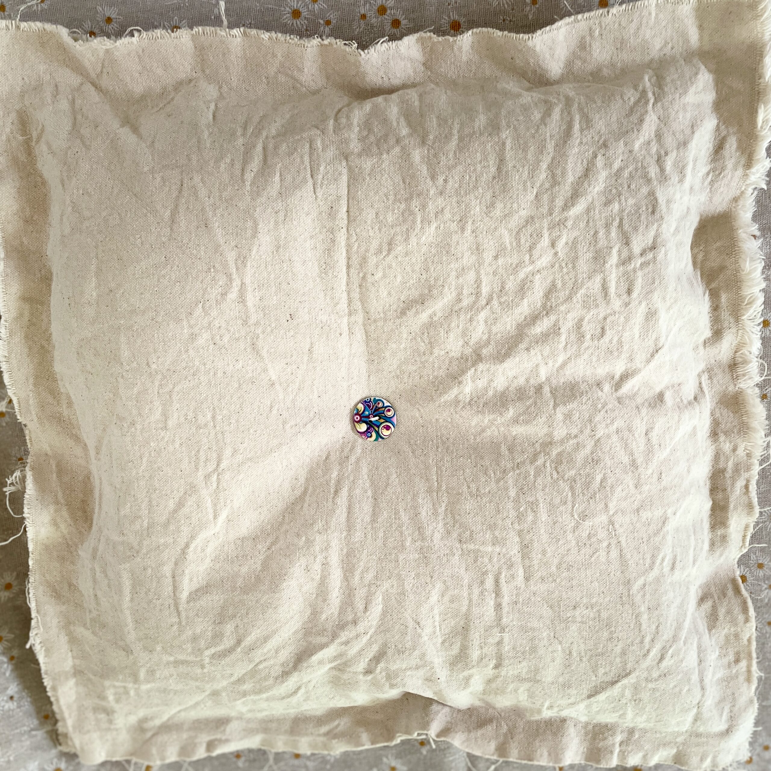 Colorful round button on beige linen cloth