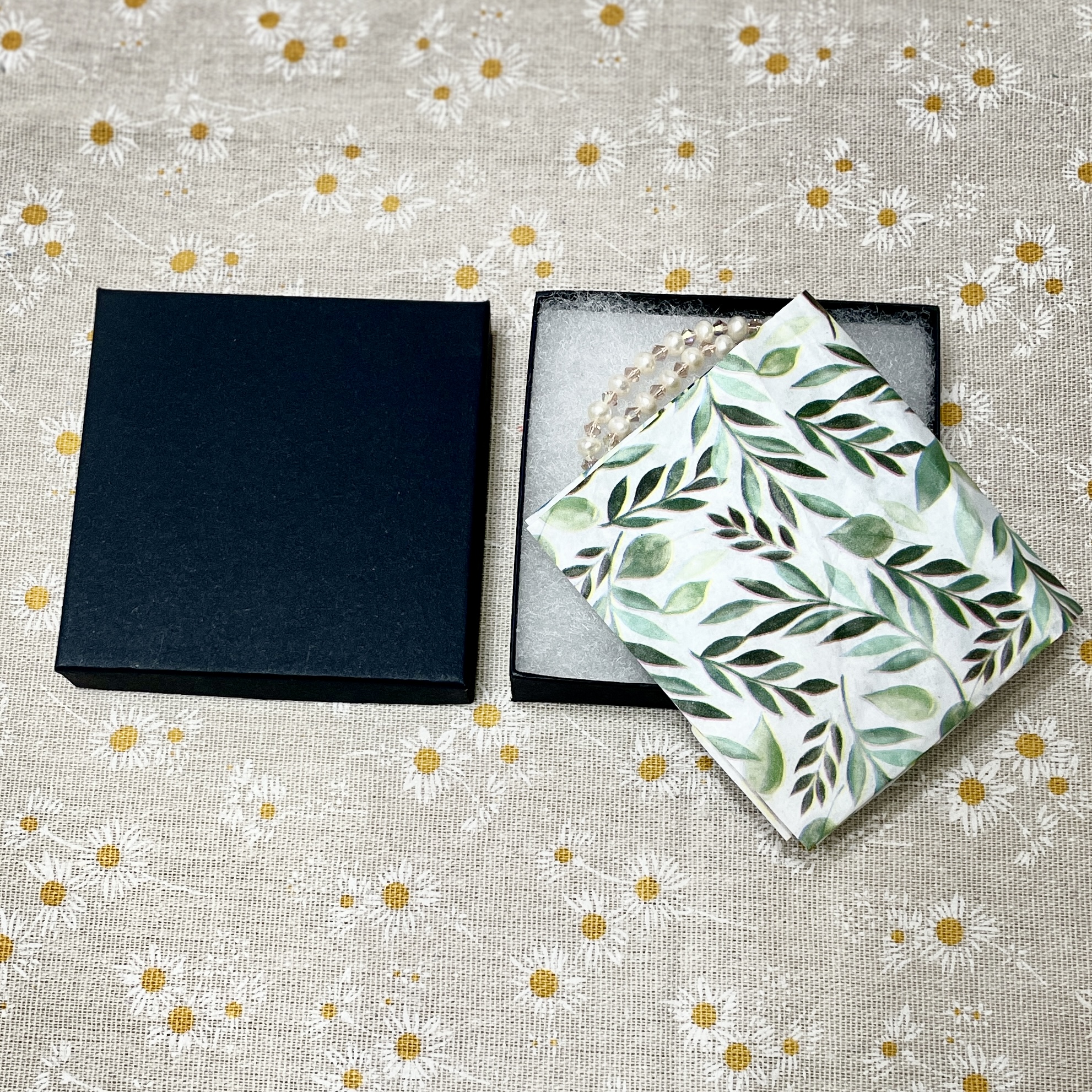Open black gift box with pearl necklace