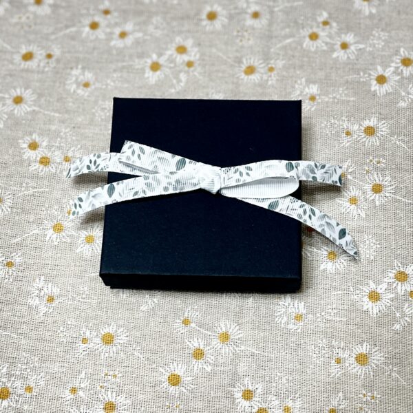 Black gift box tied with floral ribbon