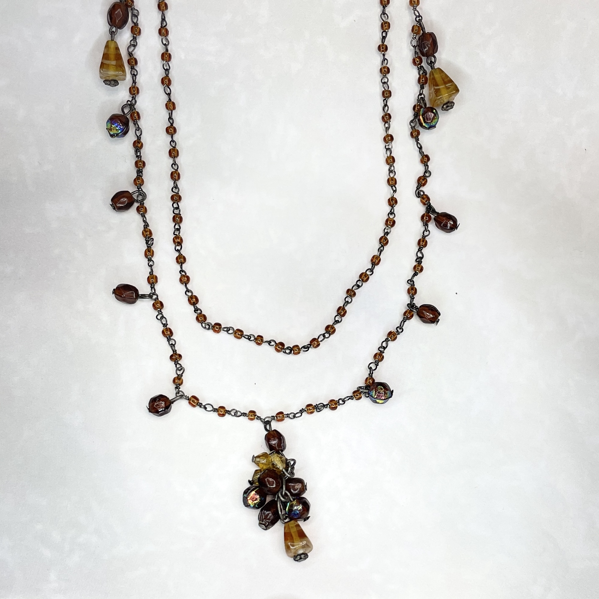 Layered brown beaded necklace with floral pendant