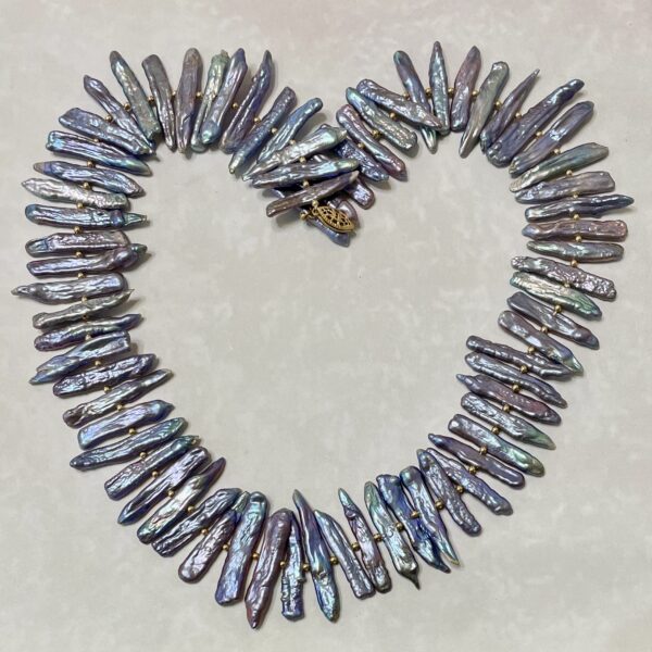 Iridescent elongated pearl necklace arranged in heart shape