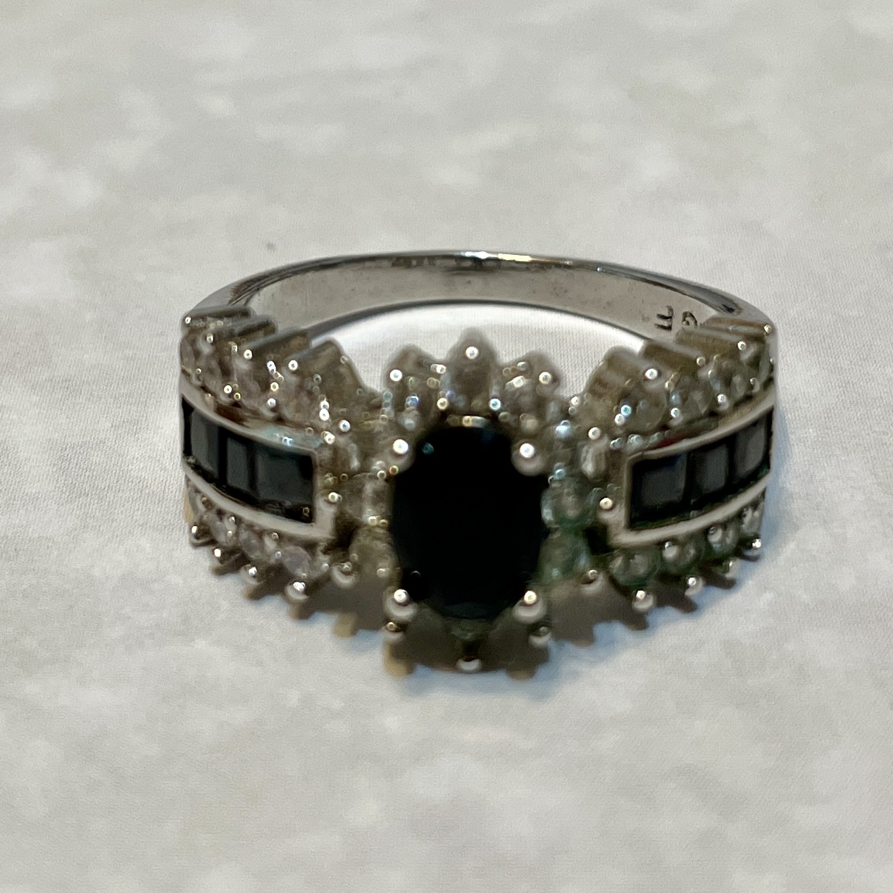 Elegant ring featuring a central black gemstone.
