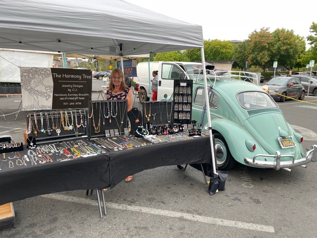 Jewelry vendor booth beside mint green Volkswagen