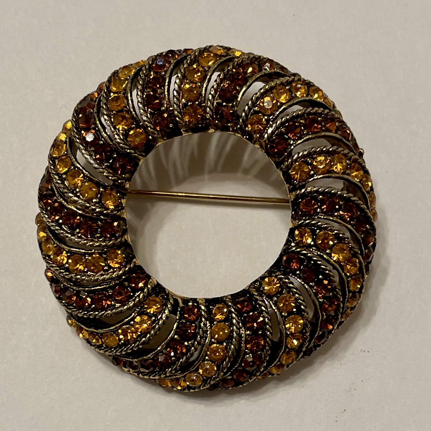 Vintage brooch with amber and gold tones.