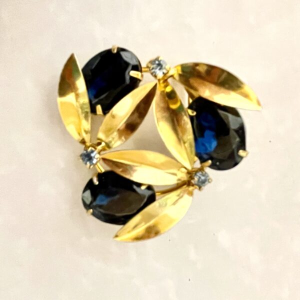 Elegant brooch with dark stones and gold leaves.