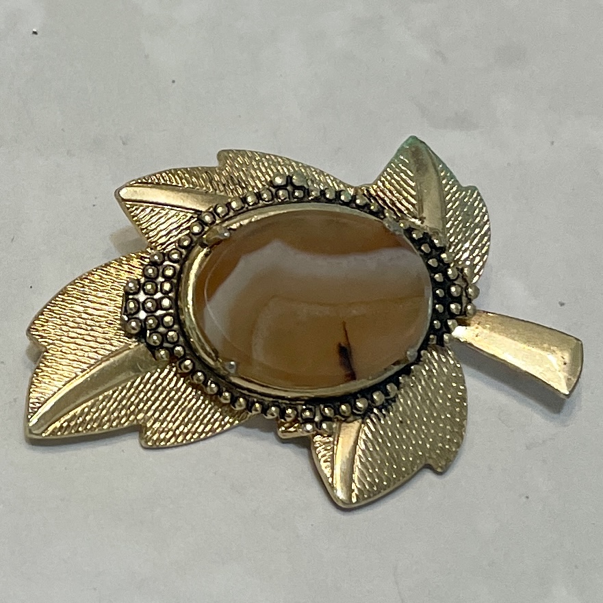 Gold leaf brooch with amber stone centerpiece.