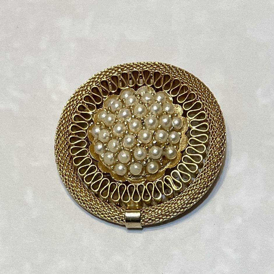 Gold brooch adorned with clustered pearls.