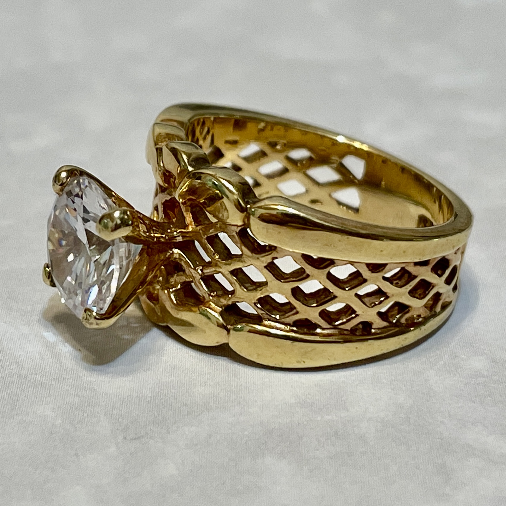 Intricate gold ring with a large gemstone.