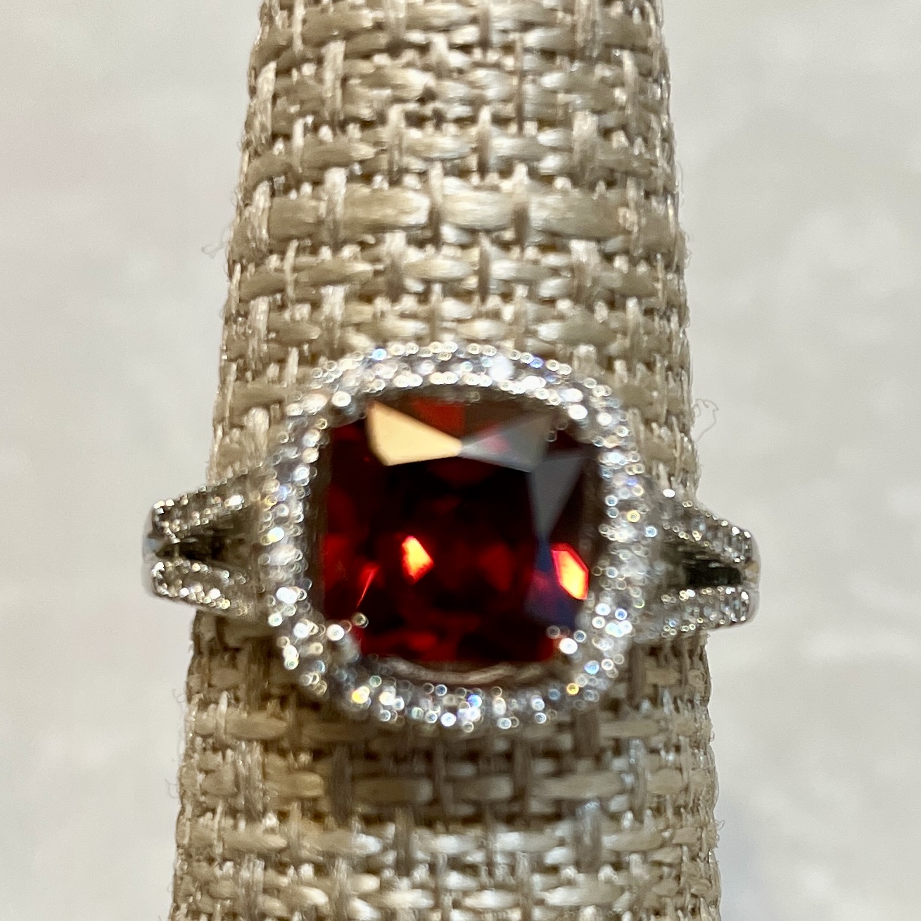 Elegant ring with large red gemstone centerpiece.