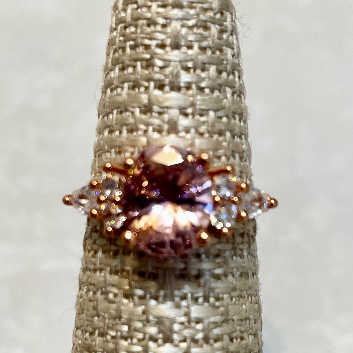 Elegant rose gold ring with pink gemstone center.