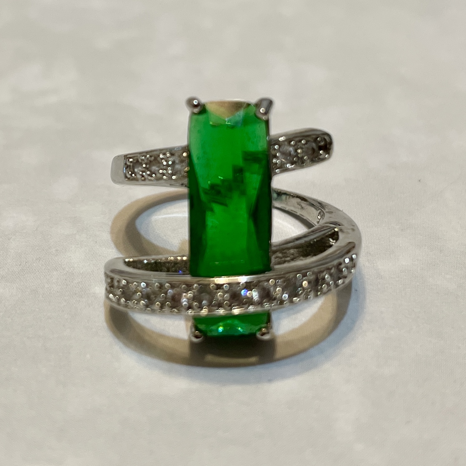 Elegant silver ring with vibrant green gemstone.