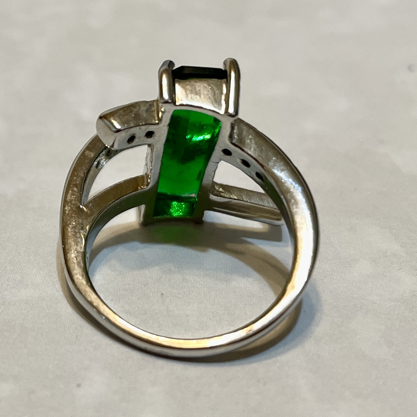 Silver ring featuring a vibrant green stone.