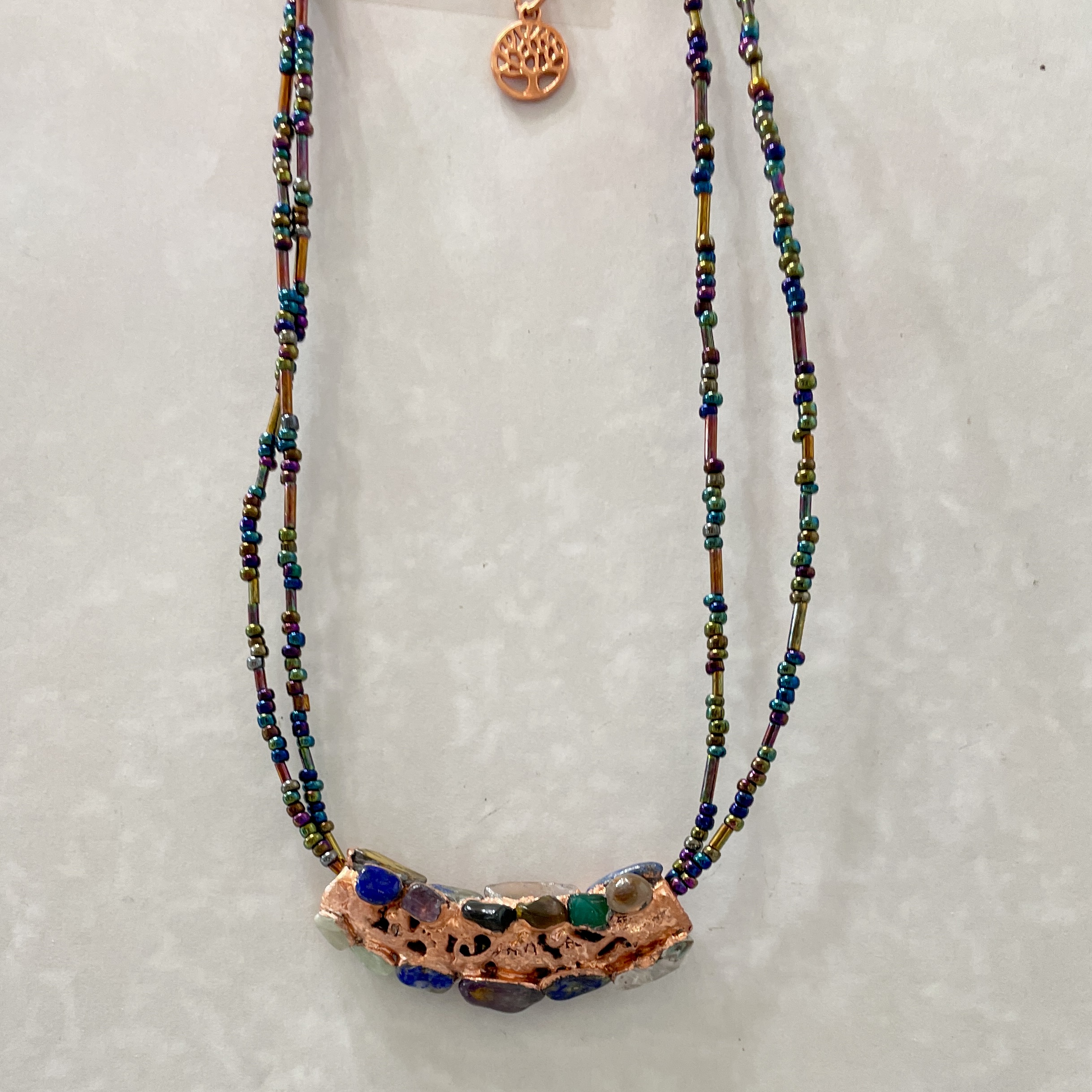 Beaded necklace with copper and gemstone pendant