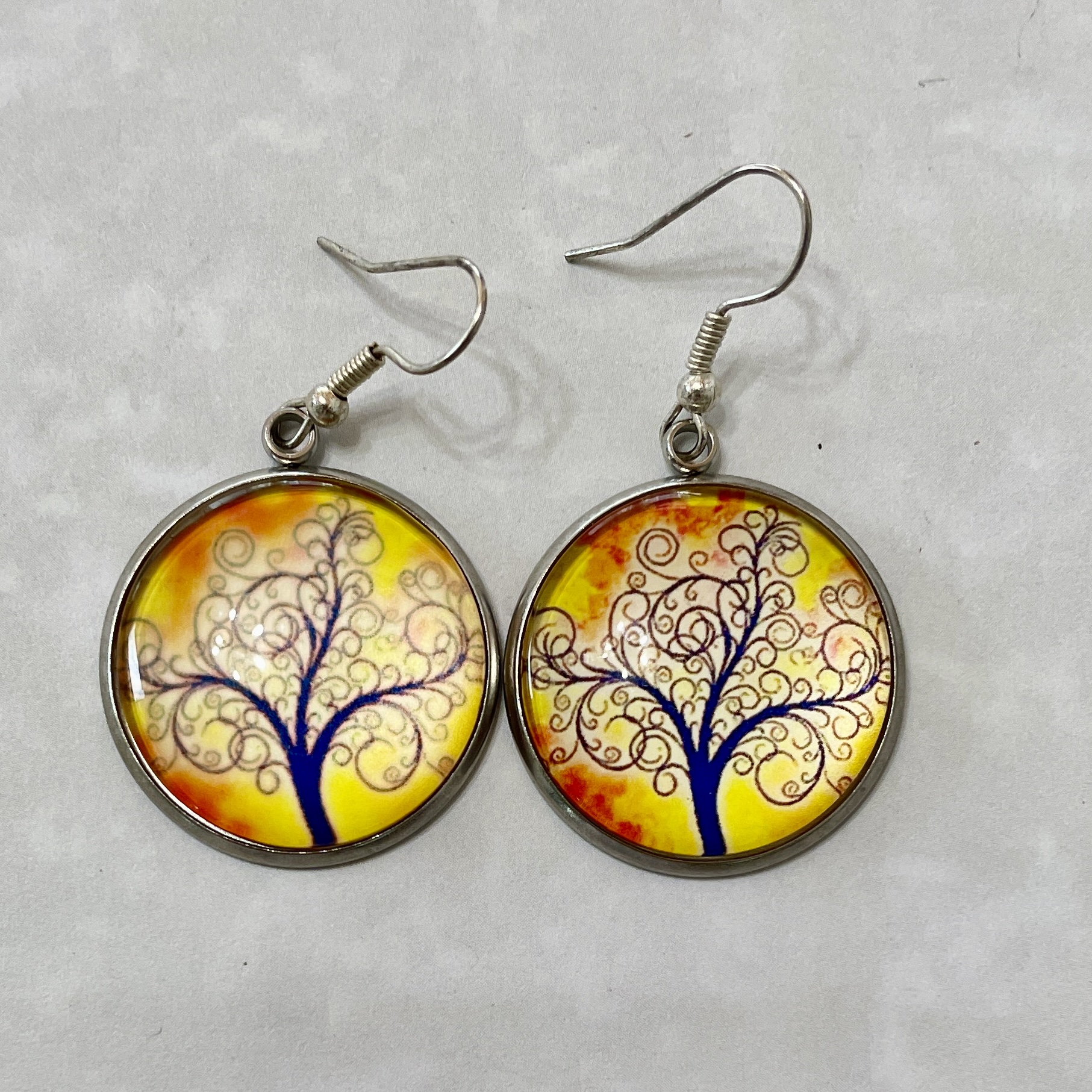 Round earrings with blue tree design