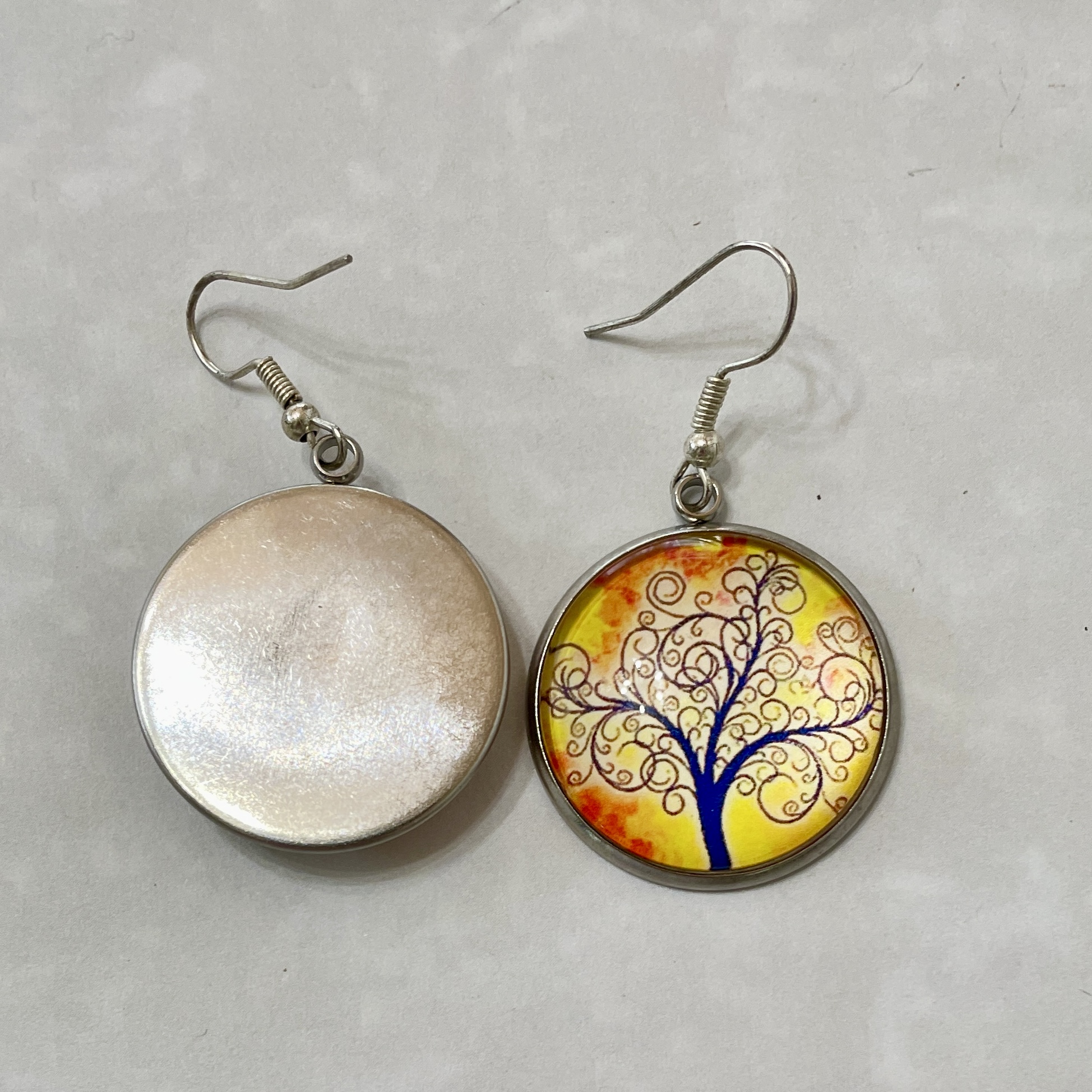 Round dangle earrings with tree design
