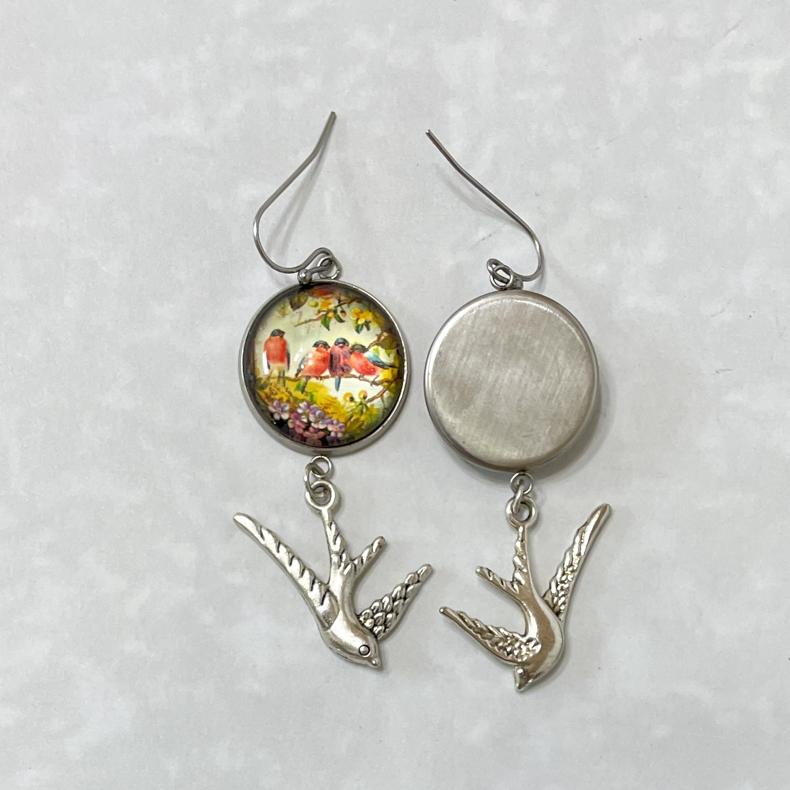 Silver bird dangle earrings with painted scene