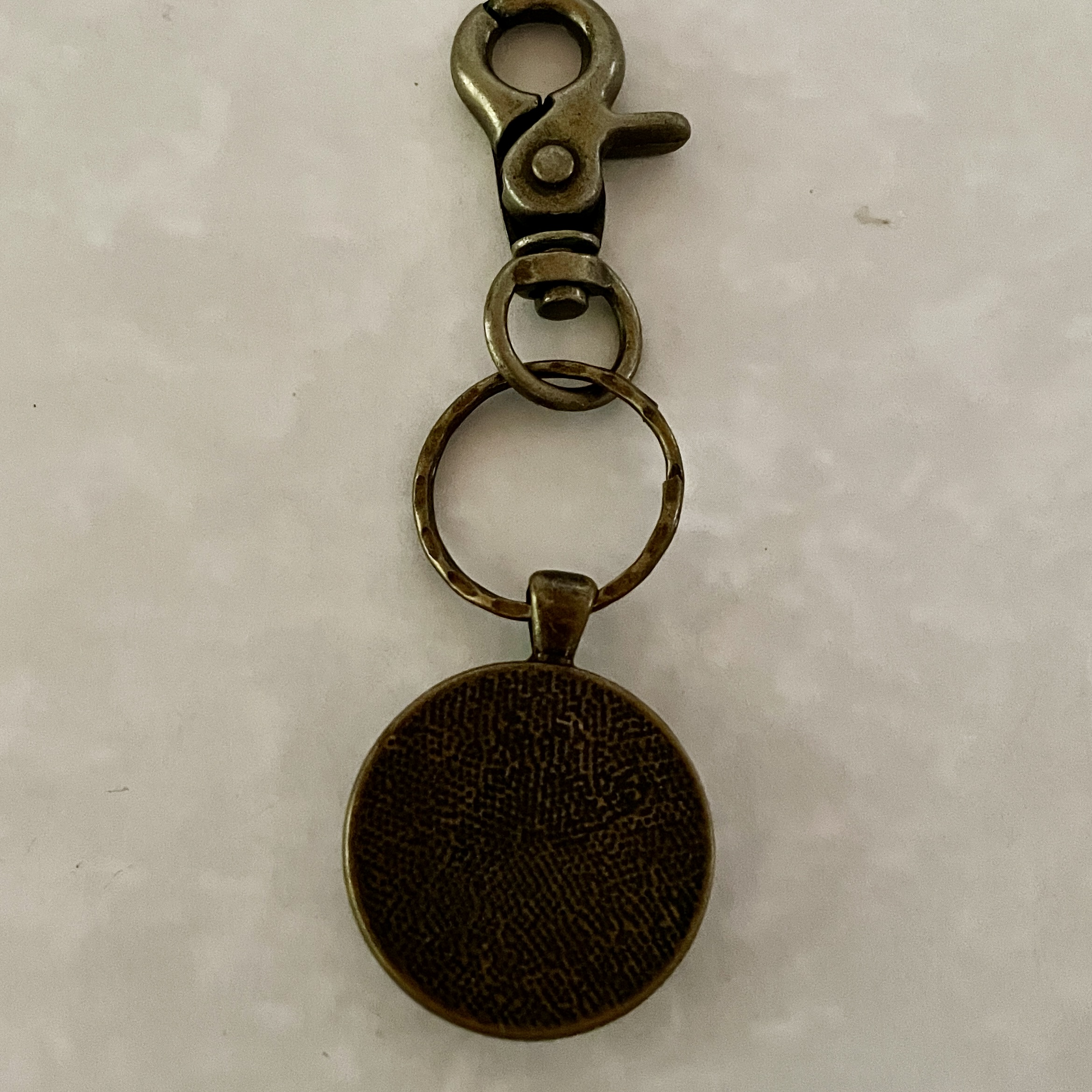 Bronze keychain with round textured pendant