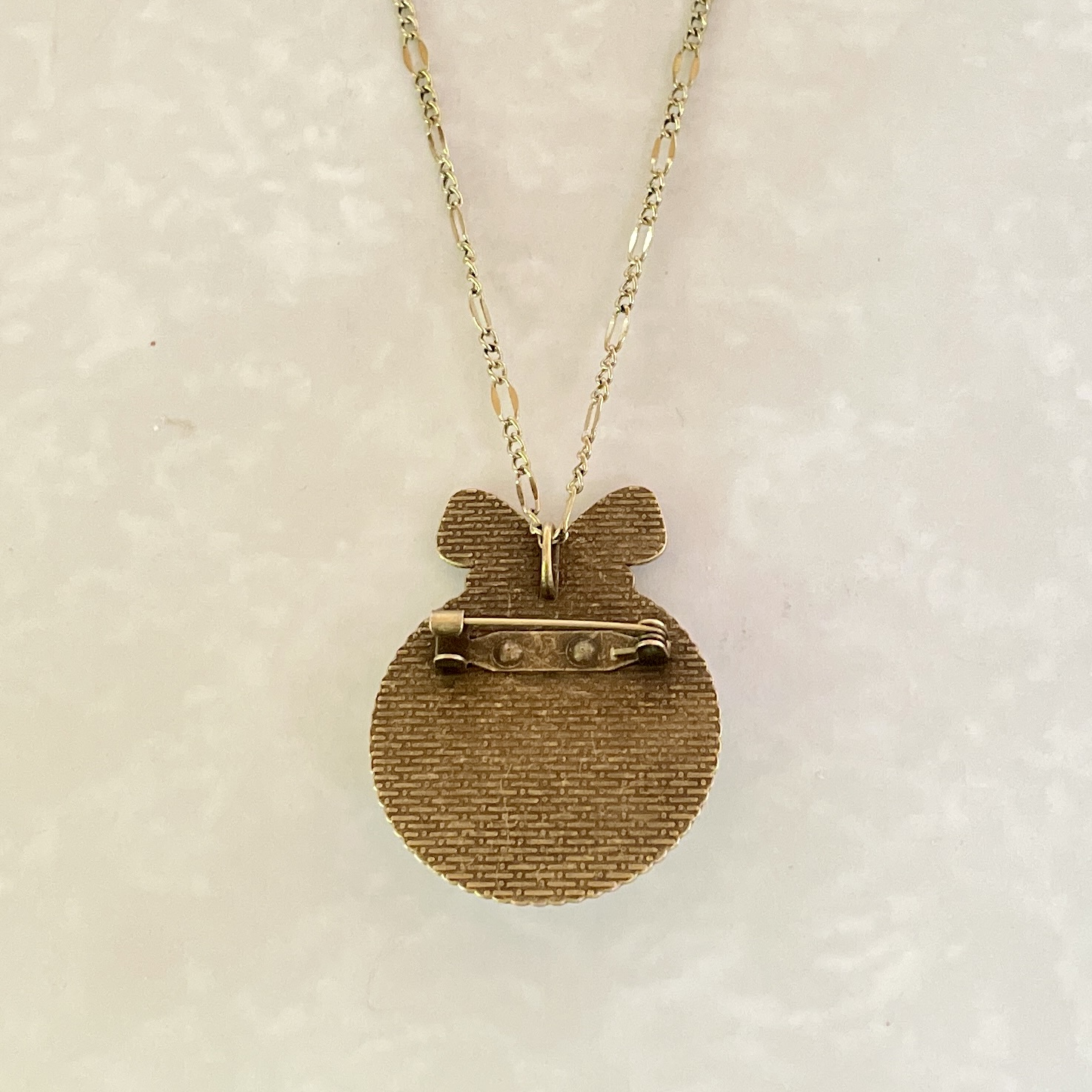 Textured gold round pendant brooch on chain