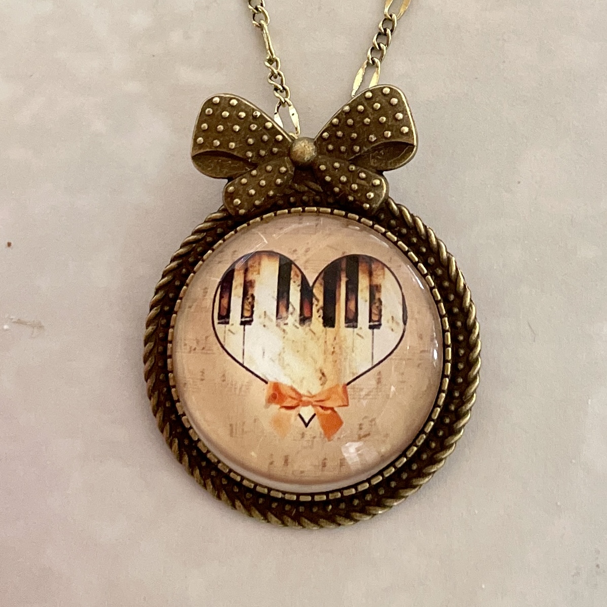 Piano-key heart pendant necklace with bow