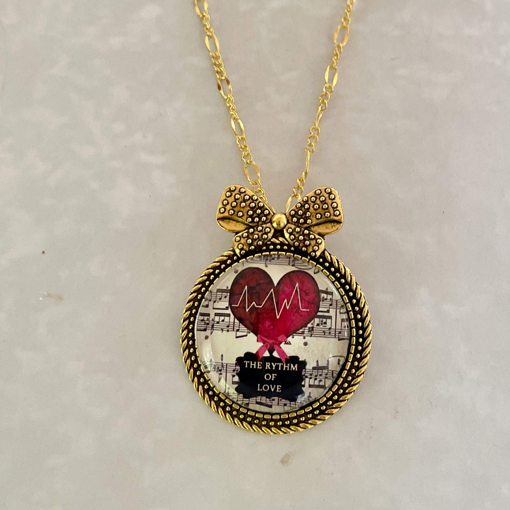 Gold bow necklace pendant with heart and music