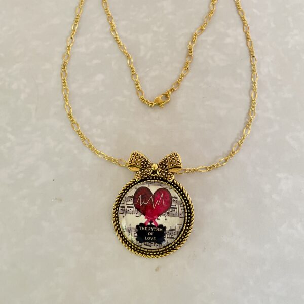 Gold bow necklace with heartbeat heart pendant