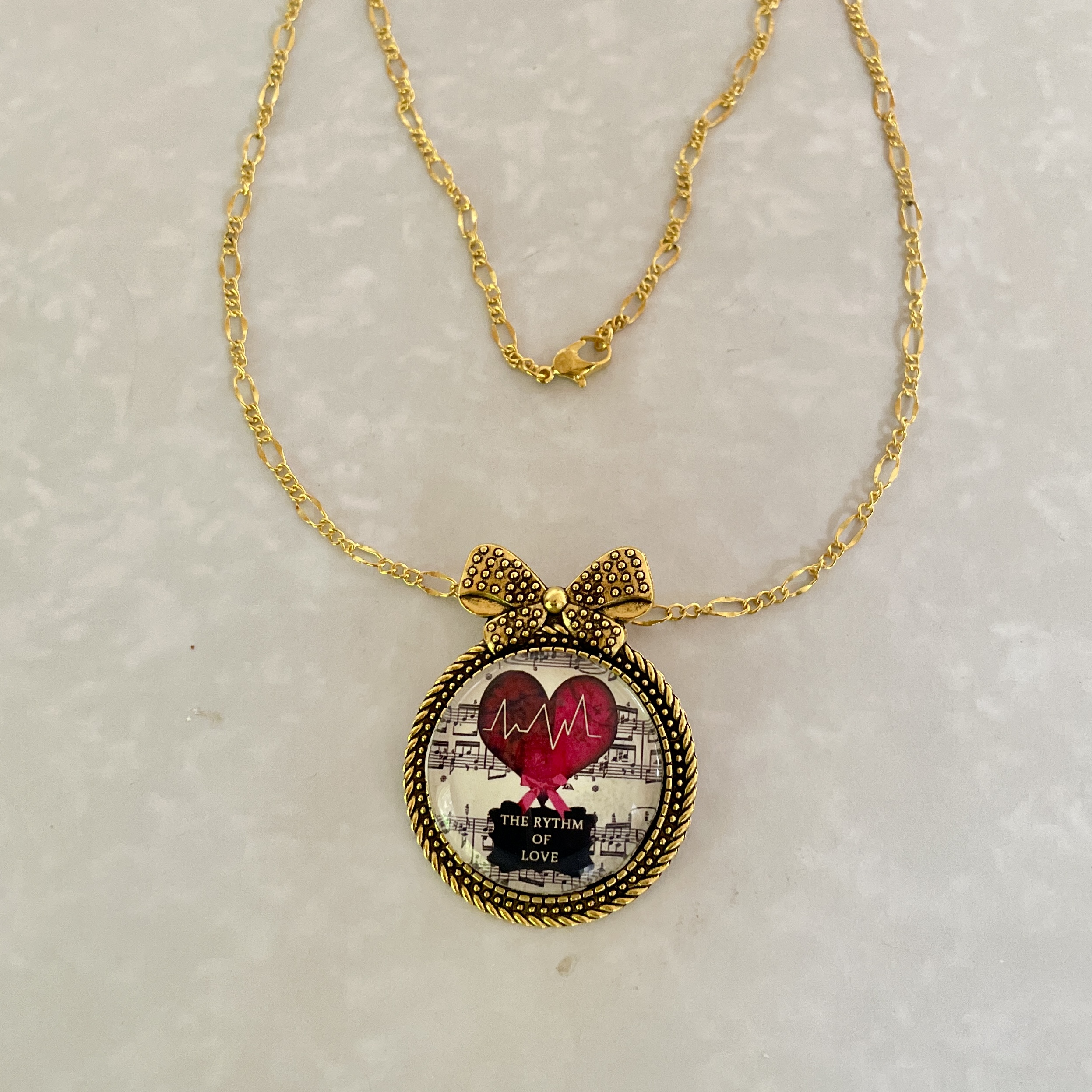 Gold bow necklace with heartbeat heart pendant