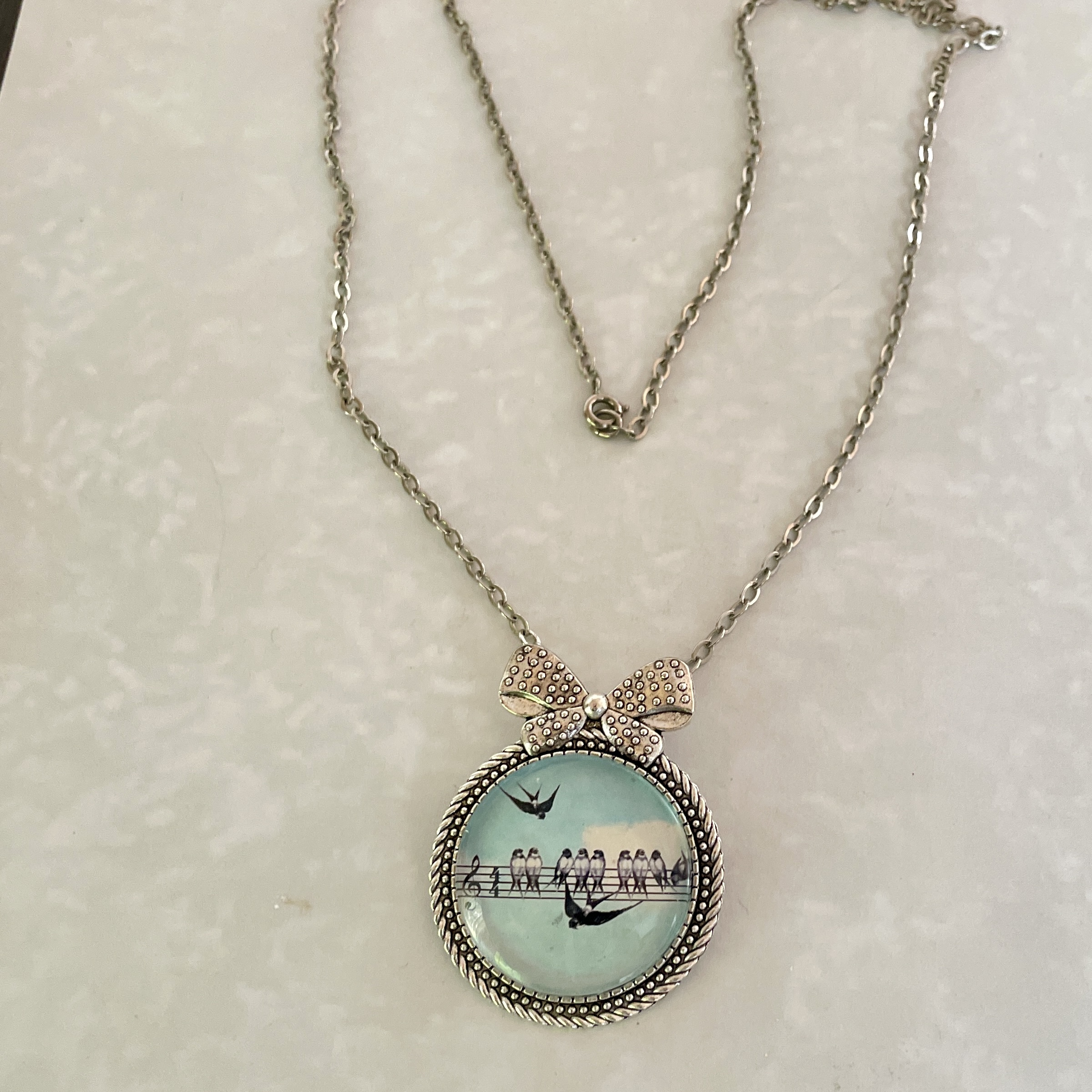 Silver round pendant necklace with birds silhouette