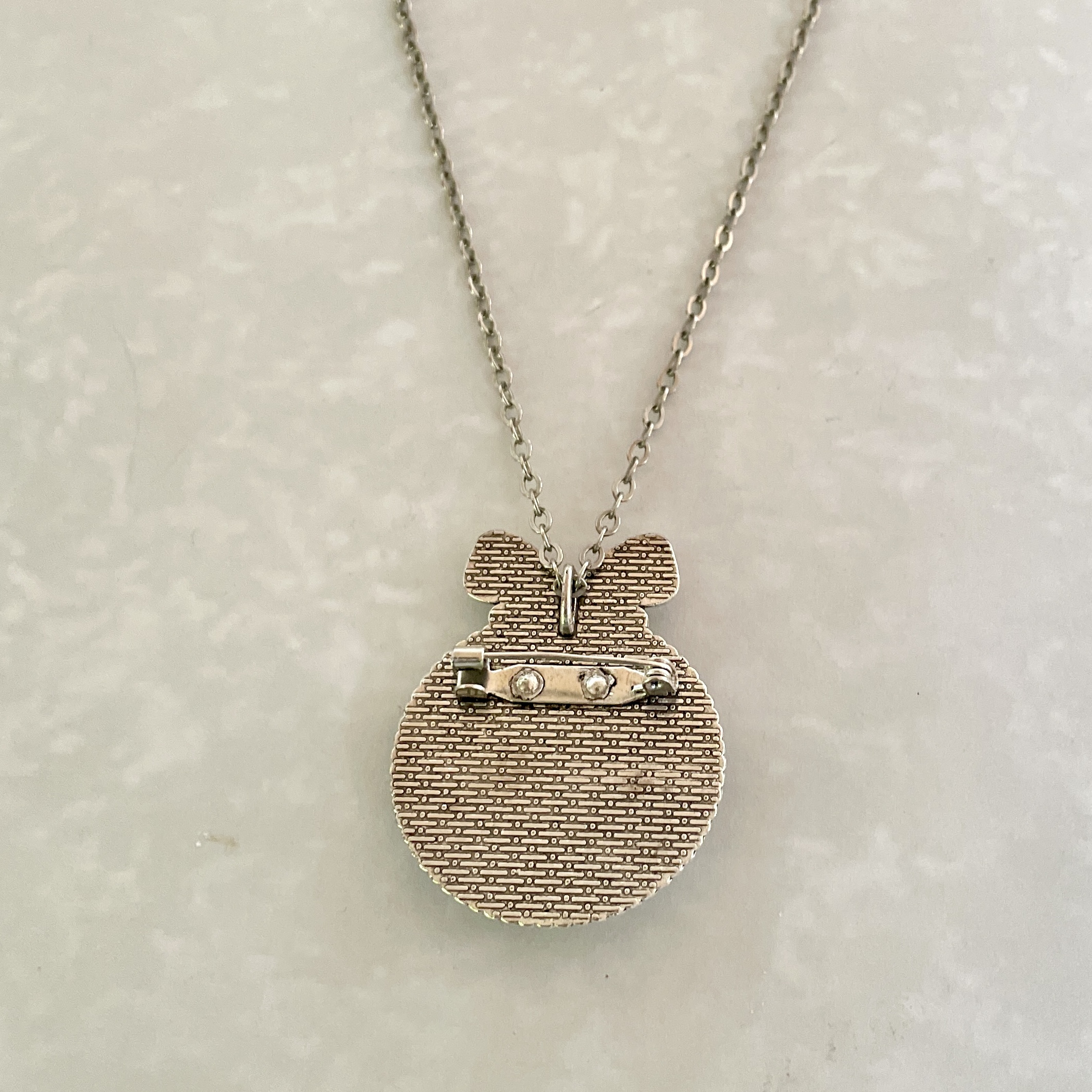 Silver textured round pendant necklace with bow